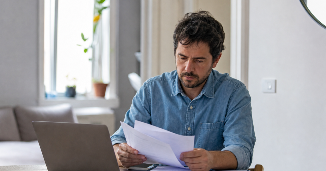 Homme en chemise bleue lisant des documents